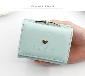 Detail of mint green tri-fold wallet with lychee leather and gold heart clasp