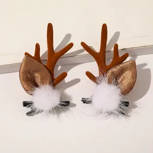 Detail of Christmas reindeer antler hair clips with plush brown fabric and white pom-poms