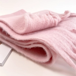 Close-up of soft pink mohair scarf showing thick plush texture and warm material