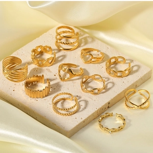 Collection of gold stainless steel rings with heart, chain and textured designs on stone