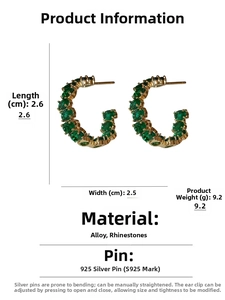 Macro view of C-shaped emerald rhinestone hoop earrings with size and weight specs