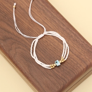 Detailed shot of three-layer beaded evil eye bracelet on dark wooden background