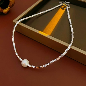 Close-up of silver beaded necklace with round white pearl charm in a premium gift box