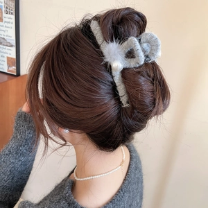 Detail der grauen Plüsch-Haarklammer mit großen Perlen für einen eleganten Winterlook