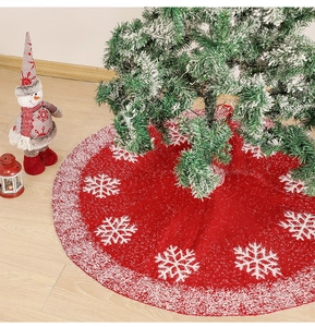 Detail of red plush Christmas tree skirt featuring white snowflake patterns and soft trim