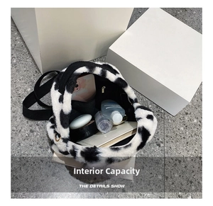 Detail showing the large interior capacity of this cow print plush backpack for daily items