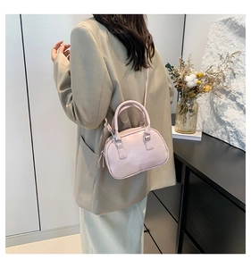 Modern crossbody view of a glossy pastel bowling bag with thin adjustable strap
