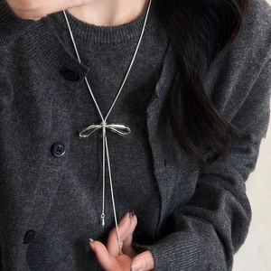 Detail of silver bow tassel necklace with adjustable sliding clasp on a model