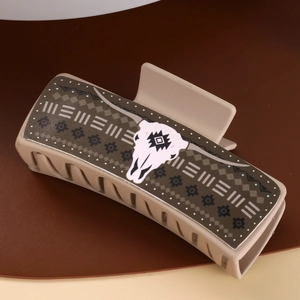 Close-up of beige leather PU claw clip with a bull skull pattern and geometric design