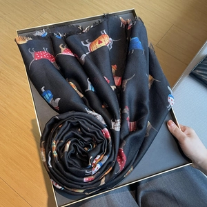 Detail of black cotton linen scarf featuring colorful dog prints and fine tassel edges