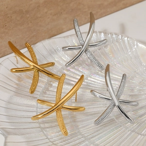 French vintage starfish cross stud earrings in gold and silver finish on glass tray