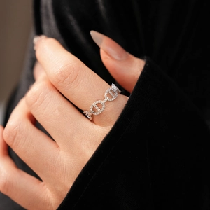 Detail of silver pig nose chain ring with pave-set zircons worn on model finger