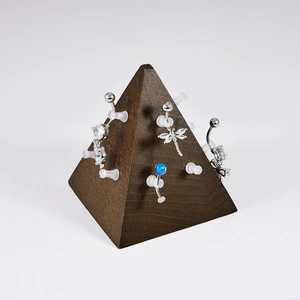 Dragonfly and opal belly rings displayed on a wooden pyramid stand for body jewelry