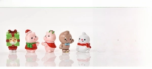 Detailed view of mini Christmas resin figurines showing snowman and piglet styles