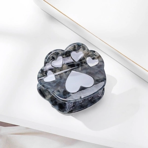 Close-up of a blue tortoiseshell cat paw hair claw clip with white heart detail