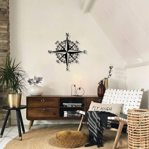 Vintage black metal compass wall decor hanging in a modern minimalist living room