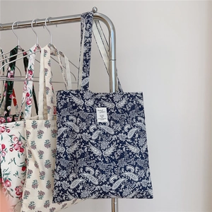 Detailed display of vintage paisley canvas tote bags hanging in three different colors