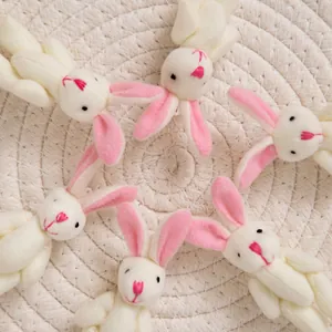 Set di 6 simpatici coniglietti di peluche bianchi con dettagli rosa su una stuoia