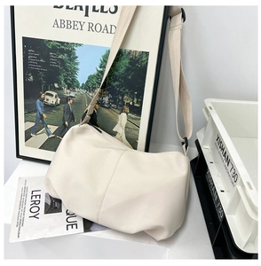 Detail of minimalist cream white pleated dumpling bag with durable nylon fabric