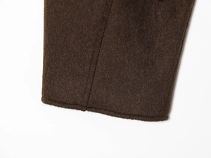 Close-up of high-quality dark brown wool jacket cuff showing detailed stitching and fabric texture