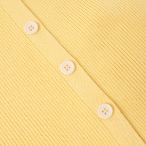 Gros plan détaillé sur la maille côtelée et les boutons en résine de la robe jaune