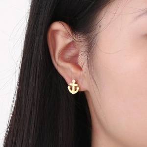 Minimalist gold anchor stud earring for women featuring a small sparkling white stone inlay