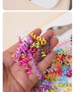 Close-up of colorful spiral phone cord hair ties in macaron colors on a hand