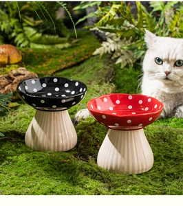 Detail of red and black mushroom-shaped ceramic cat bowls with non-slip textured bases