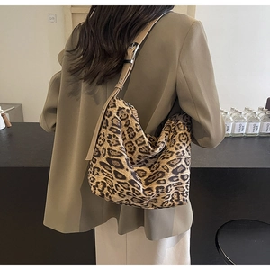 Close-up of leopard print tote bag with adjustable brown strap worn by a model