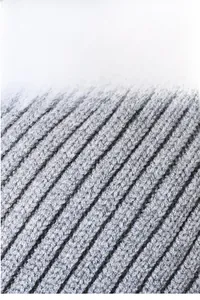 Detailed macro view of the grey ribbed knit fabric texture on this warm winter hat