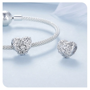 Makroaufnahme von S925 Silber Herz-Charm mit Blattmuster und Zirkonia auf einem Netzarmband