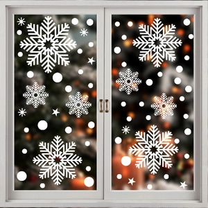 Close-up of white snowflake window clings on glass with warm holiday lighting background