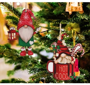 Detail of wooden gnome Christmas ornaments with Hot Cocoa print hanging on tree