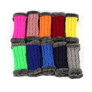 Detail view of colorful cable knit arm warmers with grey faux fur trim in various shades