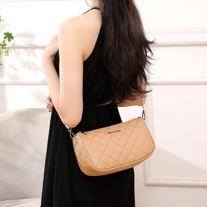 Elegant beige quilted leather cylinder shoulder bag with gold chain strap on model