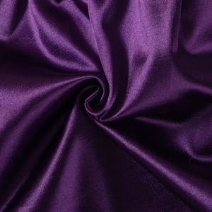 Macro shot of dark purple satin yoga shorts fabric with silky texture and metallic luster