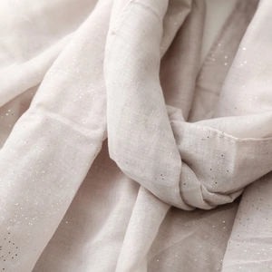 Detailed macro view of light pink cotton linen scarf with sparkling silver sequins