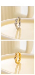 Detail of silver and gold heart-shaped zircon hoop earrings with crystal embellishments