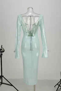 Detalle de espalda abierta de vestido de lentejuelas verde menta con cordones negros