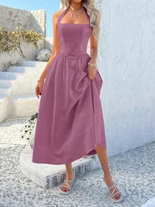 Detail of fuchsia halter neckline on maxi dress with textured fabric against white walls