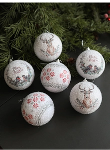 Detail of Christmas foam balls with glitter snowflakes and reindeer on pine branches