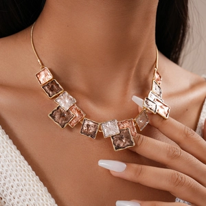 Close-up of mixed metal geometric necklaces with hammered texture on a model neck