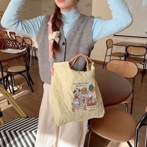Close-up of soft quilted heart texture and cute animal embroidery on a yellow bag