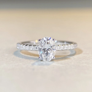 Oval cut moissanite engagement ring in S925 sterling silver with pavé diamond band