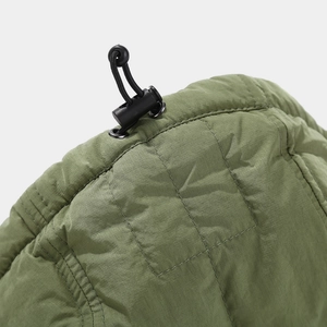 Detailed close-up of army green quilted cap with adjustable black spring toggle and drawstring