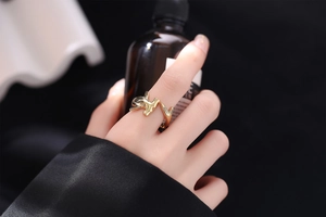 Detailed view of a gold-tone adjustable shark ring featuring intricate embossed textures