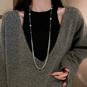Close-up of elegant multilayer pearl necklace with silver chains and fringe tassels