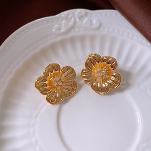 Macro shot of 18k gold plated flower stud earrings with sparkling zircon center details