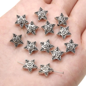 Detailed view of silver star-shaped alloy pendants with face design held in hand