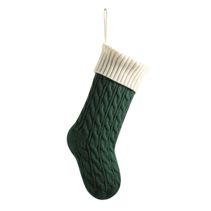 Deep green cable knit Christmas stocking with creamy white ribbed cuff and hanging loop
